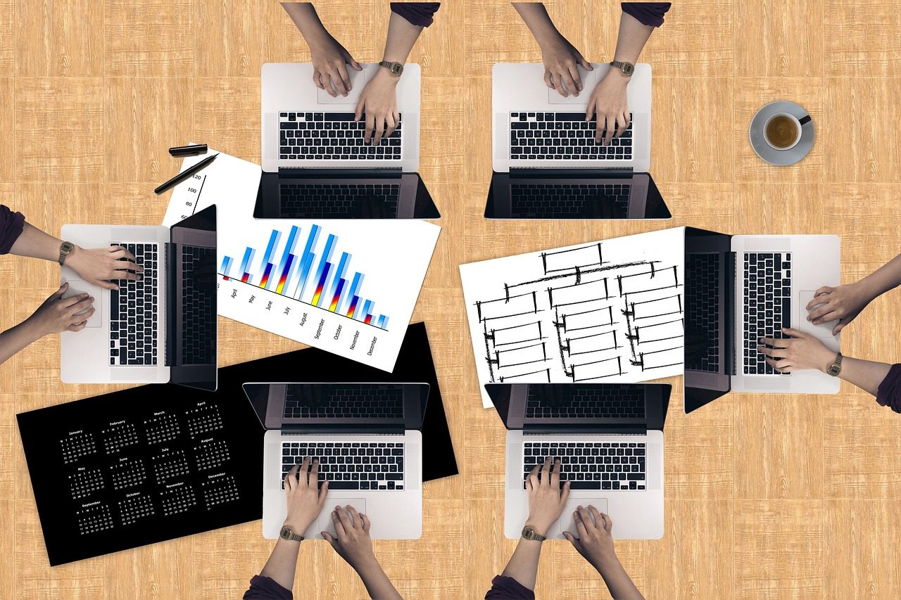 Meja kerja dengan laptop dan lembar grafik data
