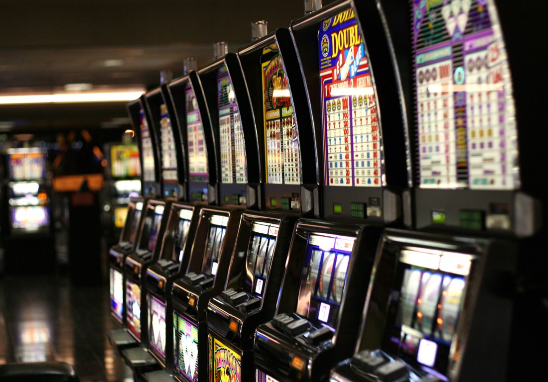 Deretan mesin slot menyala di ruang kasino