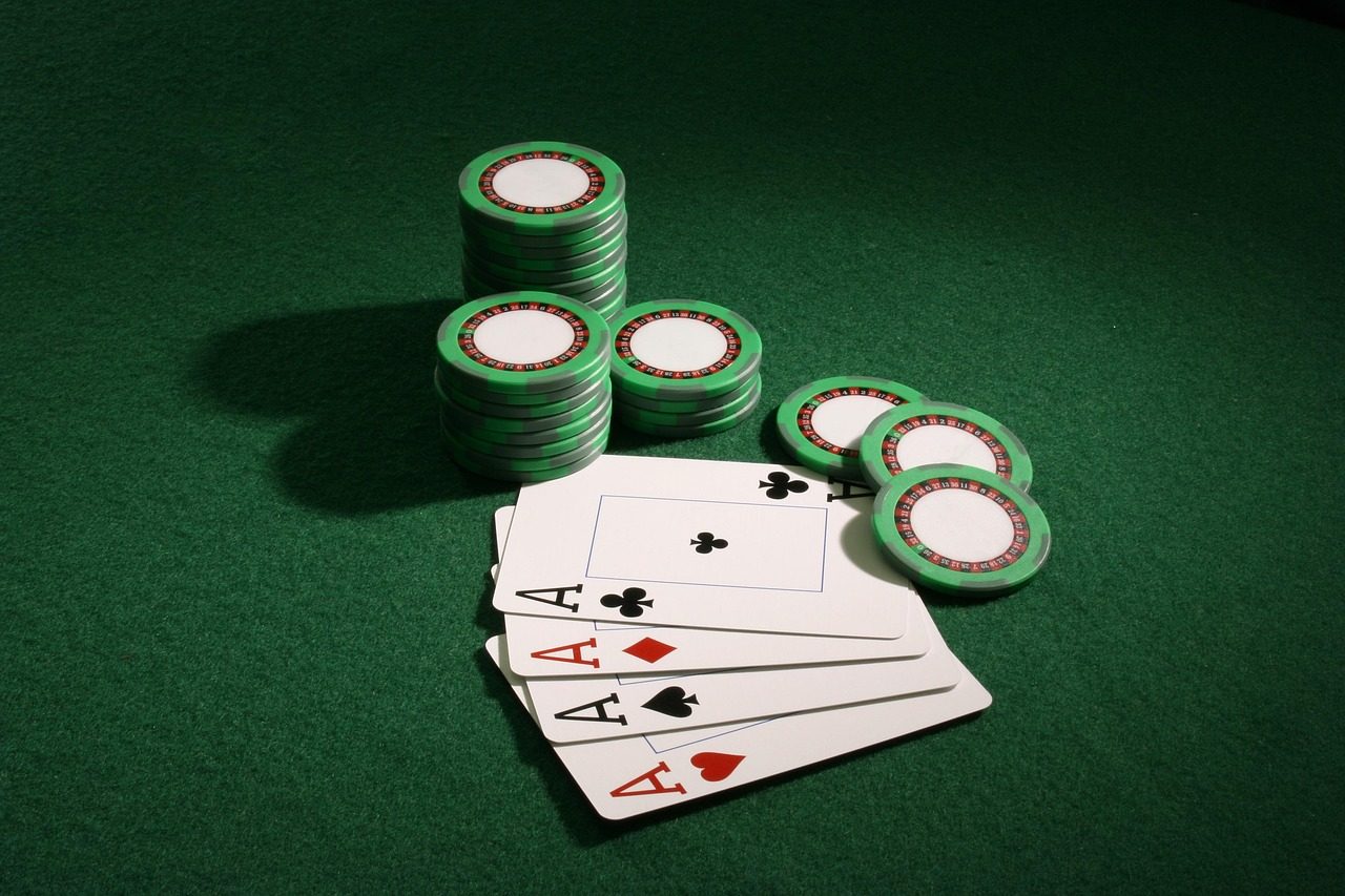 Chip kasino hijau bertumpuk di samping kartu as