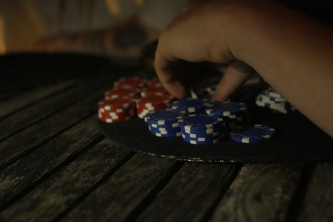 Tangan meraih chip poker biru dan merah