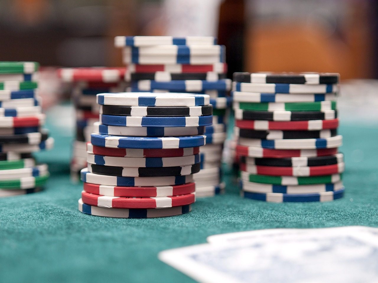 Tumpukan chip kasino di meja hijau