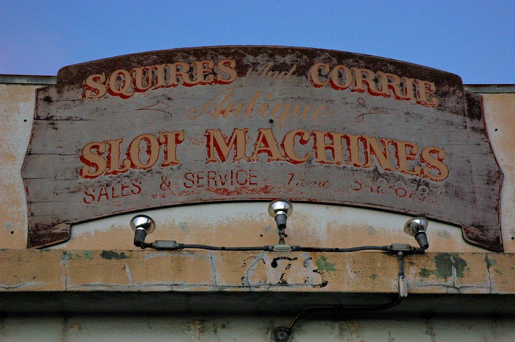 Papan tua bertuliskan slot machines sales and service