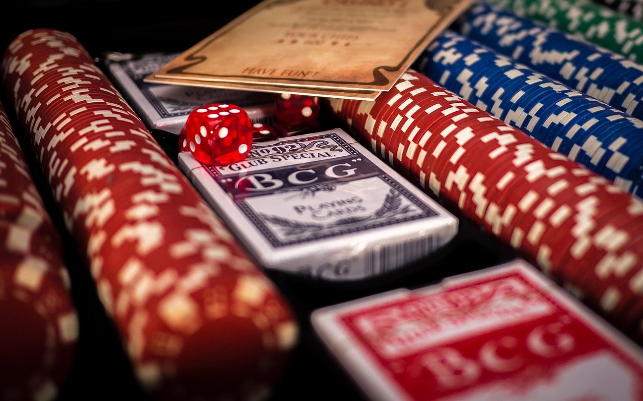 Chip kasino, dadu merah, dan kartu remi di dalam kotak